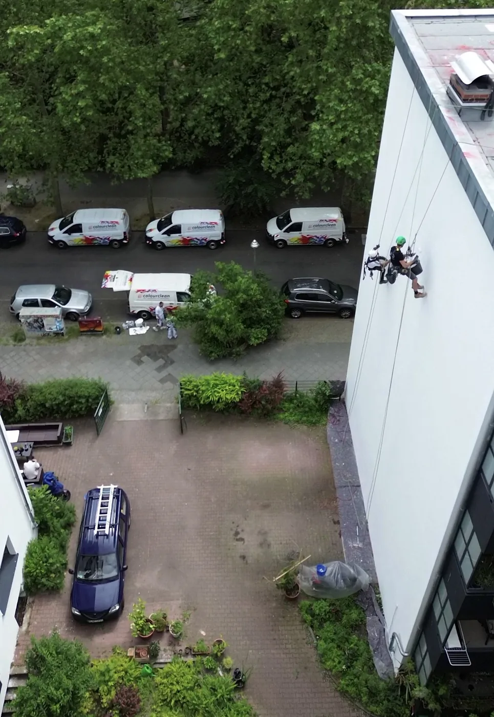 Blick vom Dach auf den Seilkletterer an der Fassade