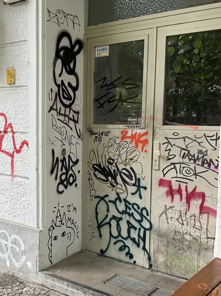 Hauseingangstür in Berlin mit Graffiti-Tags, vorher
